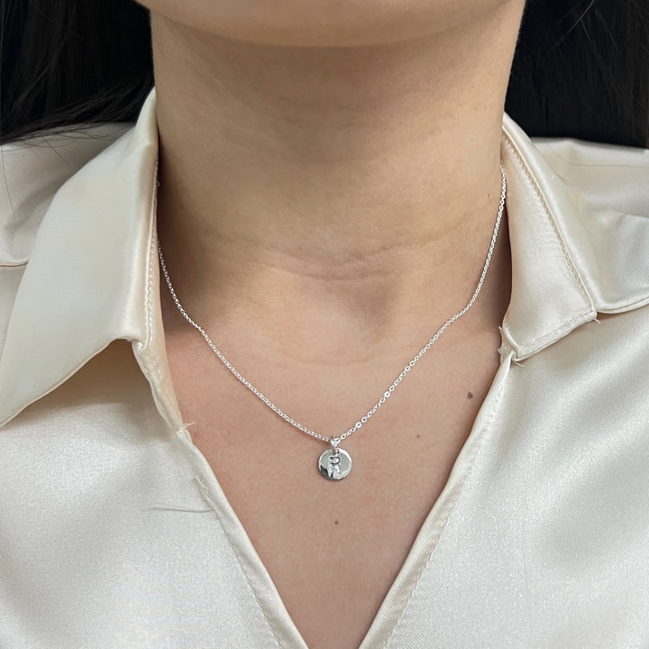 Collar de plata 925 con la letra R en el cuello de la modelo