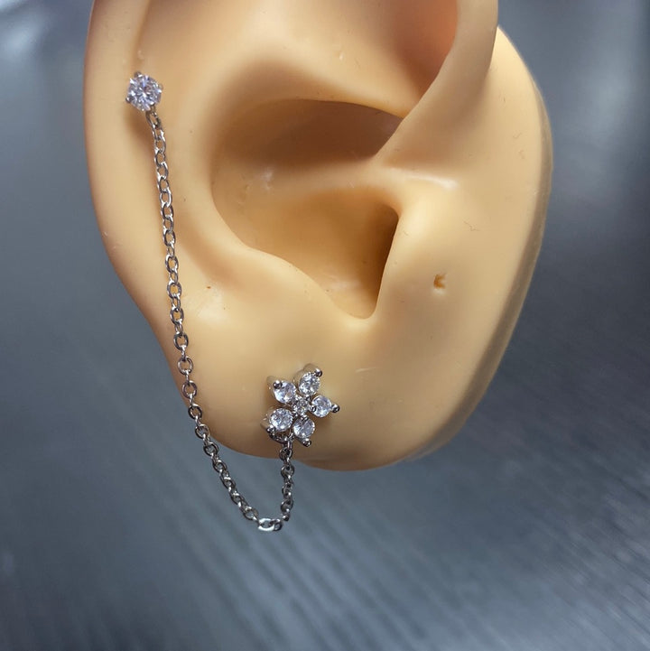 Arete Quirúrgico 🌼 Flor Plateada Con Cadena