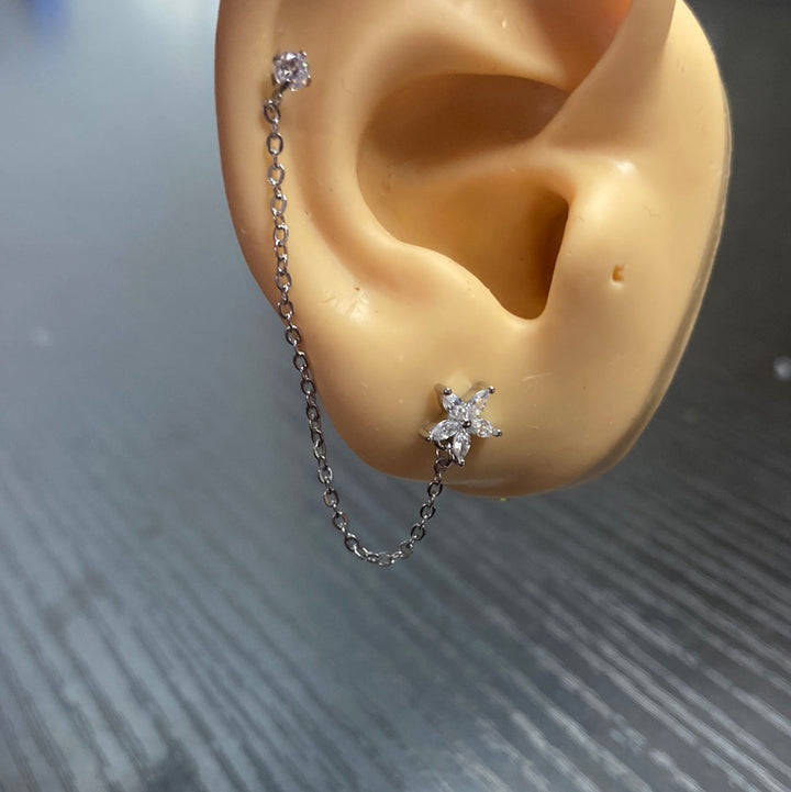 Arete Quirúrgico 🌼 Flor Plateada Con Cadena